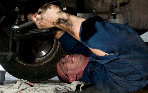 A mechanic performs a routine oil change