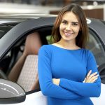 Woman leaning against her vehicle