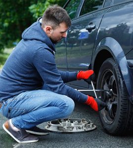 man changing tire because of a flat